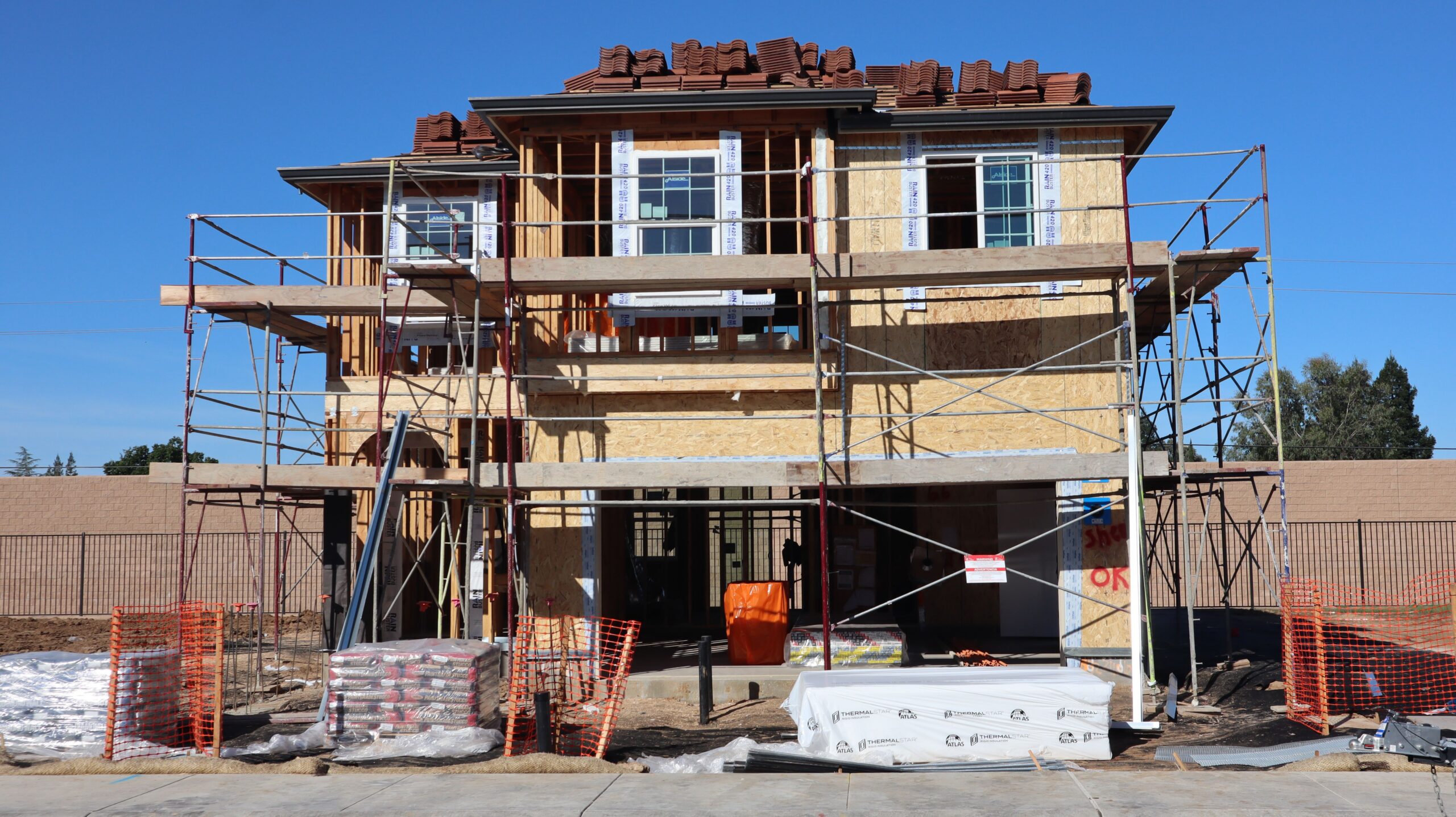Construction underway for a new home in Elk Grove, California. Scaffolding and materials onsite.
